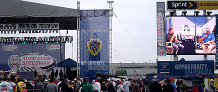 Wide shot of stage/screen w/Ryan Newman.